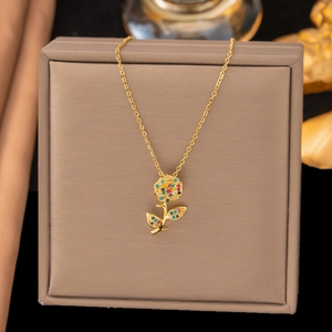 Elegant gold rose flower pendant necklace with colorful cubic zirconia in a jewelry box