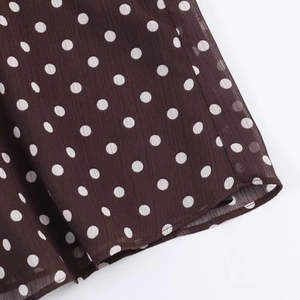 Detail shot of brown chiffon fabric with white polka dots and fine rolled hem stitching