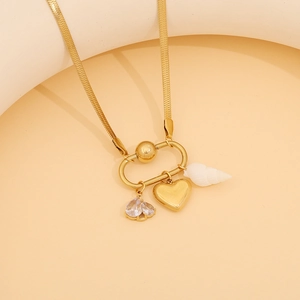 Detail of gold snake chain with detachable heart, seashell and conch charms
