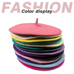 Close-up of stacked colorful wool berets showing various fashion shades and texture