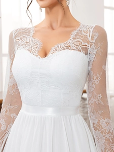 Close-up of elegant V-neck lace embroidery and sheer long sleeves on a white wedding dress