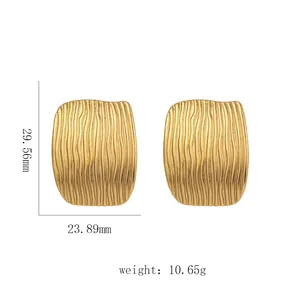 Detailed view of wide 18k gold earrings with wavy texture, 29.56mm size and 10.65g weight