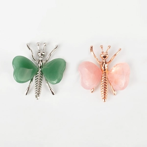 Detail of silver and rose gold butterfly brooches with heart-shaped crystal wings