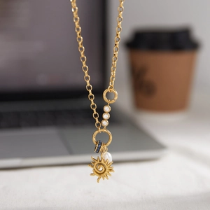 Collier avec pendentif soleil doré, perle d'eau douce et zircon bleu sur chaîne rolo