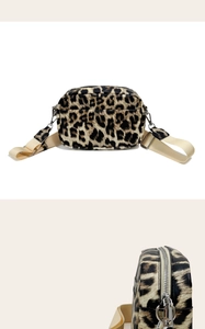 Detail of leopard print crossbody bag with silver hardware and beige wide fabric strap