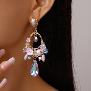 Close-up of vintage drop earring with purple crystals and floral resin on model