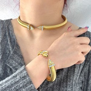 Detail view of a gold-plated snake tube necklace and bracelet set with sparkling rhinestones