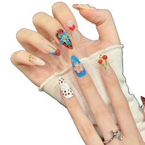 Artistic press-on nails featuring 3D flowers, cherries, and hearts in almond shape
