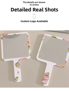Close-up of square handheld mirrors with detailed pink floral patterns and white frame
