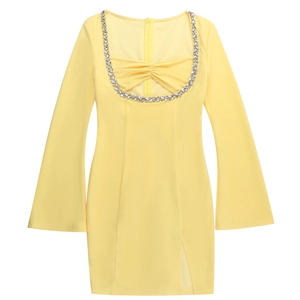 Détail de la robe jaune à encolure carrée avec strass et manches évasées élégantes