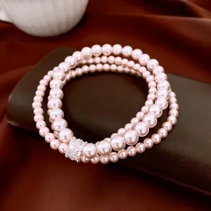 Bracelet multicouche en perles crème avec fermoir en zircon sur tissu en soie