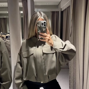 Giacca oversize da donna con zip in verde oliva con orlo a pieghe e tasche cargo