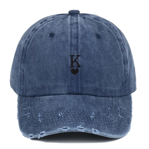Macro detail of washed denim baseball cap featuring heart and K embroidery on top