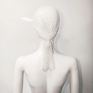 Dettaglio del copricapo a rete con perline bianche ed elegante drappeggio sui capelli