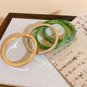 Minimalist resin marbled and metallic geometric bangles stacked on a linen stand