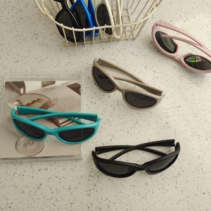 Detail view of UV400 oval sunglasses in multiple colors on a marble surface