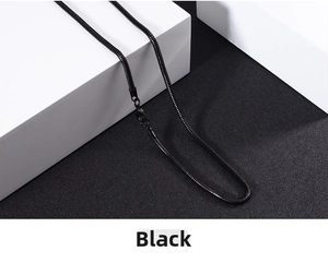 Close-up of black stainless steel snake bone chain with lobster clasp on geometric stand