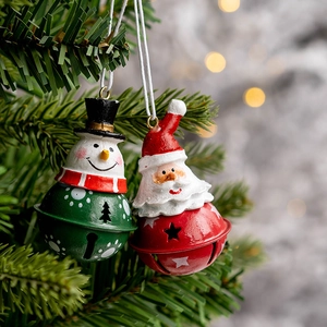 Festive Christmas bell ornaments featuring Santa and Snowman hanging on a pine tree