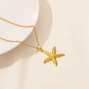 Minimalist gold starfish pendant necklace with detailed texture on a round link chain