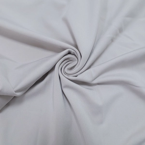 Close-up of grey textile fabric texture showing fine ribbed knit and soft drapery detail
