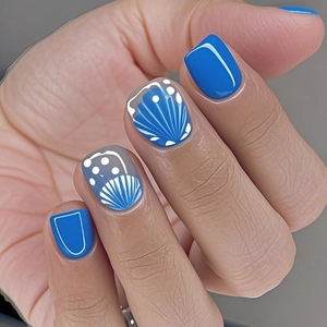 Fresh blue press-on nails with white polka dots and seashell texture on a model's hand
