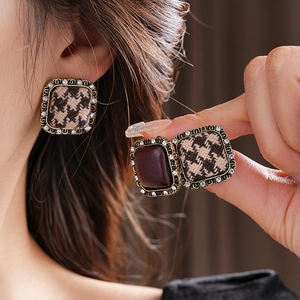 Dettaglio di orecchini vintage quadrati con tessuto pied de poule e piccoli strass