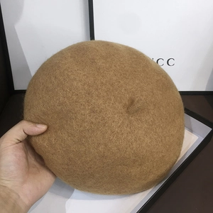 Top view detail of a camel wool felt beret showing soft texture and vintage round crown