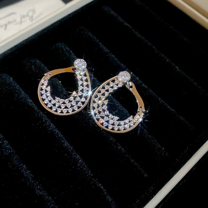 Gros plan de boucles d'oreilles argentées en forme de larme serties de zircons cubiques