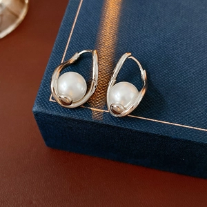 Macro shot of French vintage pearl earrings with twisted silver metal on a jewelry box