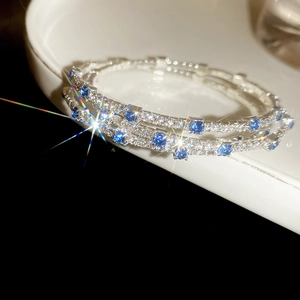 Macro shot of silver-plated bracelets with cubic zirconia and sea-blue gemstones
