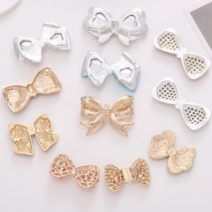 Detailed view of assorted gold and silver zinc alloy bow charms for DIY accessories