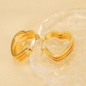 Three-layer heart-shaped 18K gold earrings with U-shape design on yellow silk background