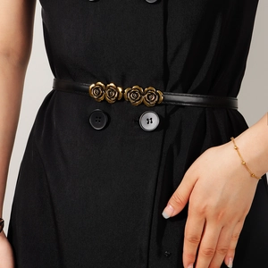 Detail of elegant black skinny belt with golden rose flower metal buckle on dress