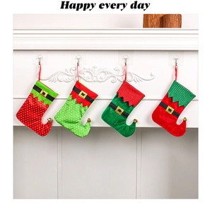 Set of four elf-style Christmas stockings with bells hanging on a white fireplace mantle