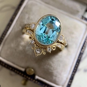 Ensemble de bagues couronne dorées avec zircon ovale bleu clair et détails pavés