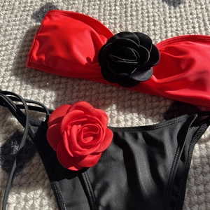 Detailed view of bicolor bikini featuring large 3D fabric flowers and side-tie bottoms
