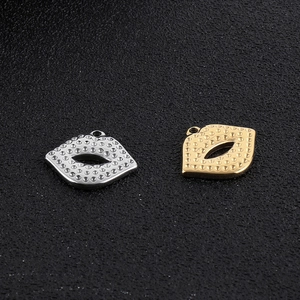 Detail of lip-shaped stainless steel charms in gold and silver finish with textured surface