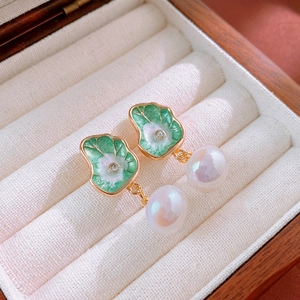 Vue détaillée de boucles d'oreilles lotus en émail vert avec perles et dorures