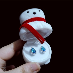 Blue teardrop earrings with crystals inside a festive snowman-shaped jewelry box