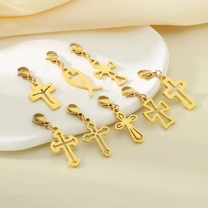 Eight gold hollow cross and fish pendants with lobster clasps on a white stone tray