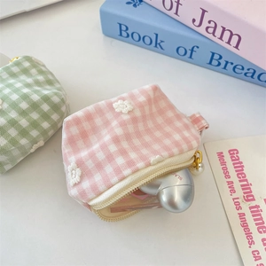 Detail of plaid mesh mini pouches with floral embroidery and pearl zipper charms
