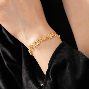 Gros plan d'un bracelet géométrique doré serti de zircons clairs sur velours foncé