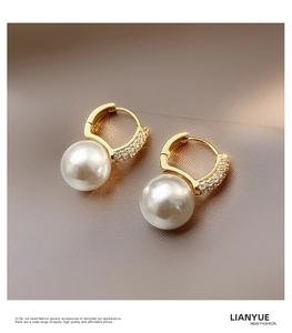 Macro detail of pearl drop earrings with sparkling zircon micro-pave on champagne silk