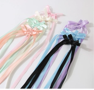 Detail view of colorful long satin ribbon bow hair clips in seven elegant pastel shades