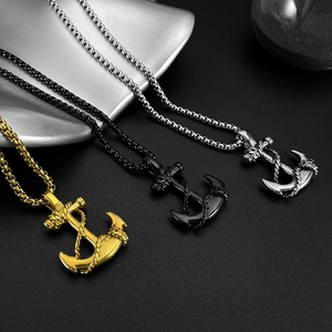 Detailed view of anchor cross pendants in gold, black, and silver stainless steel