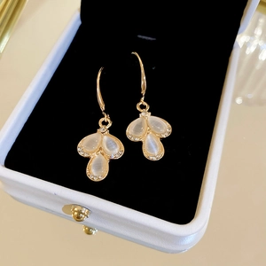 Elegant gold drop petal earrings with cat eye stones and diamonds in a jewelry box