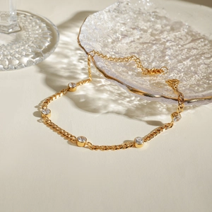 Detailed view of an 18k gold plated stainless steel chain bracelet with five zircon stones