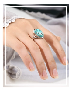 Close-up of a 925 silver oval ring base featuring a natural turquoise gemstone on a finger