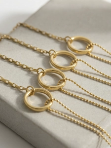 Detailed macro view of asymmetric 18K gold-plated geometric circle bracelet with box chain