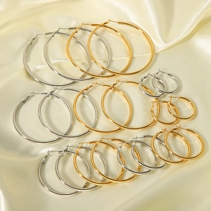 Chic 18K gold and silver stainless steel hoop earrings set on elegant silk fabric